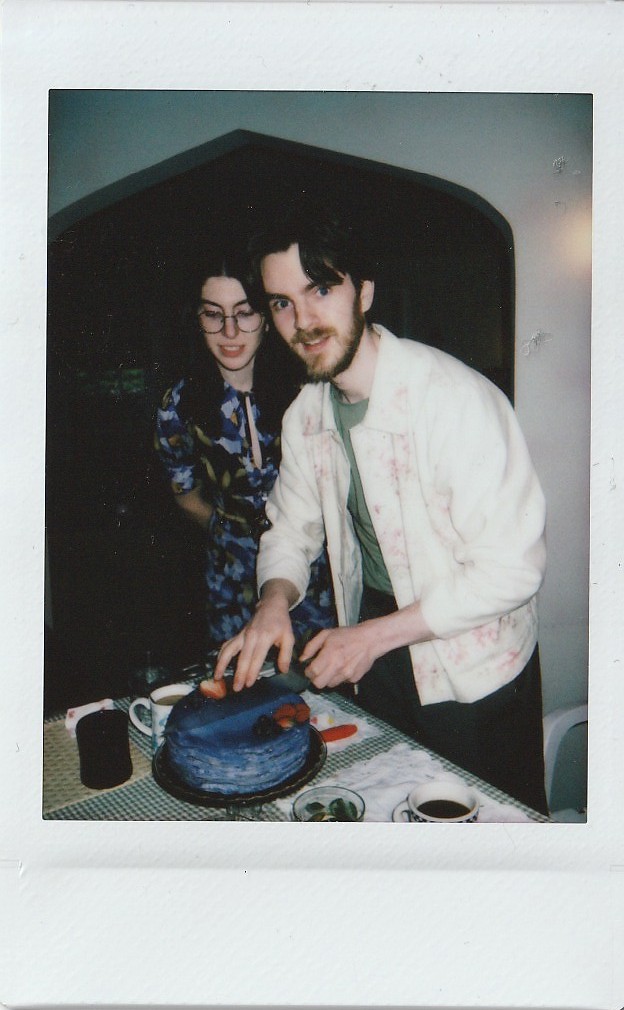 A polaroid of Jen and Morgan cutting their engagement cake!
